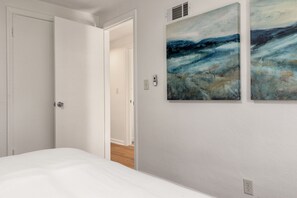 A bedroom with a bed, a white door, and two abstract paintings on the wall. - 3BR/1BA Updated South Bend Retreat Close to ND (South Bend)