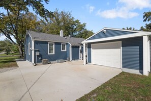 Une maison d’habitation avec un garage et une véranda.