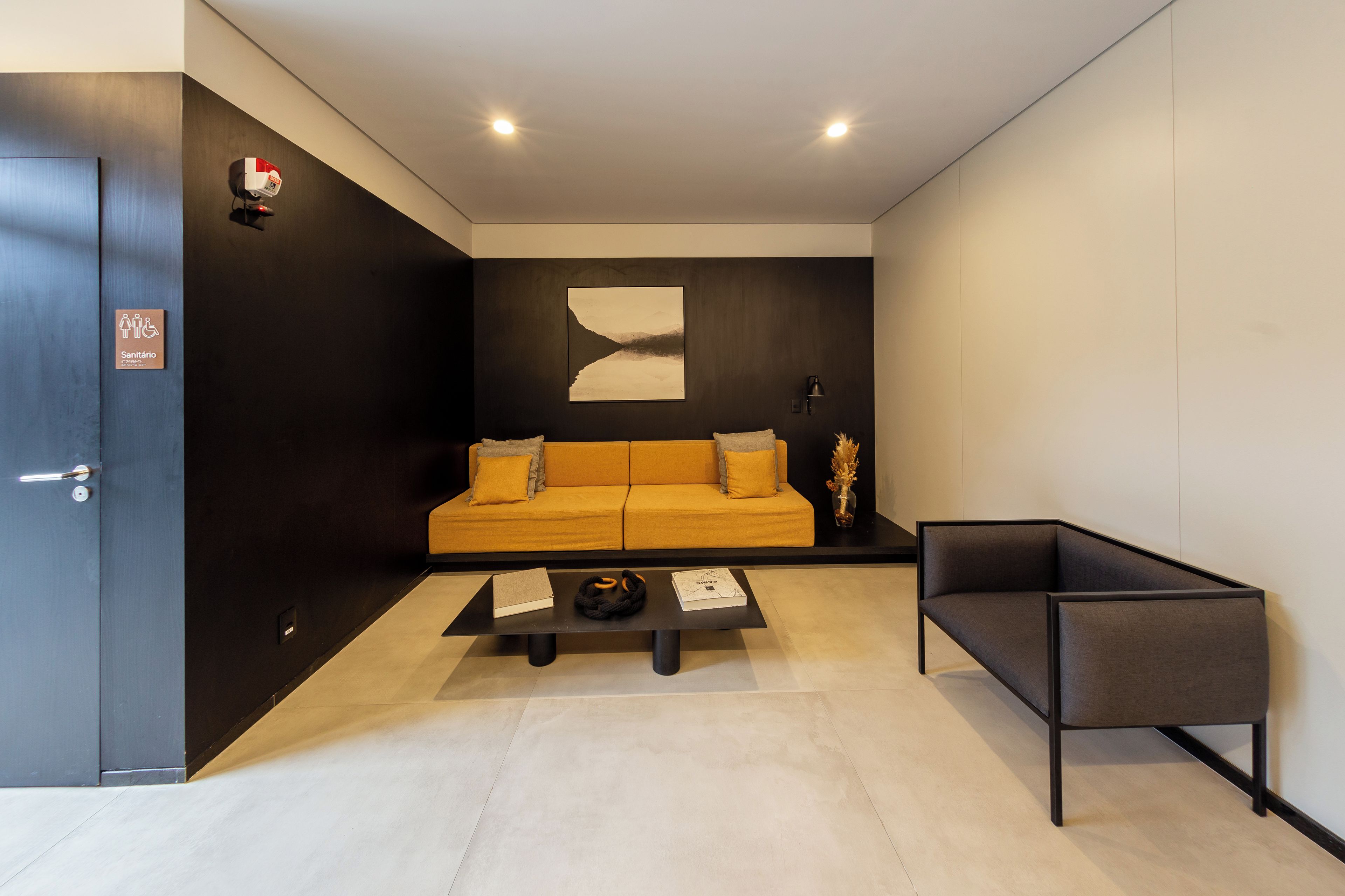 A modern living room with a sofa, a coffee table, and a side table with a lamp.