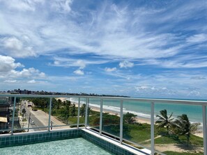A pool with a view of a beach and cityscape. - Paradise flat (João Pessoa)
