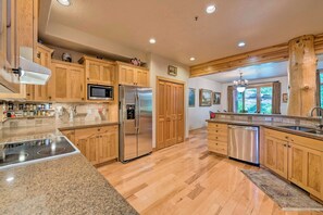 A kitchen with wooden cabinets, stainless steel appliances, and a herringbone floor pattern. - Fabulous 2-bedroom townhome in Park City on bus route (Park City)