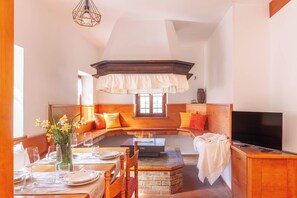 A cozy room with a dining area, a fireplace, and a television.
