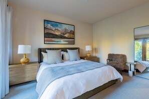 A hotel room with a large bed, two bedside tables, a chair, a painting on the wall, and a view of the outdoors through a window. - Newly Furnished 3BR Ski Townhome Sleeps 8 + Private Hot Tub (Mountain Village)