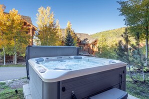 A hot tub in a natural setting with a wooden cabin in the background. - Newly Furnished 3BR Ski Townhome Sleeps 8 + Private Hot Tub (Mountain Village)