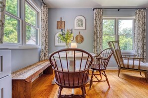A dining area with a wooden bench, two wooden chairs, a table, and a lamp. - Gettysburg 2-Bedroom Suite for 4 - Kitchenette, Hot Tub & Sauna (Gettysburg)