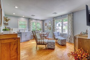 A spacious kitchen with wooden cabinets, a dining area with a table and chairs, and large windows offering a view of the outdoors. - Gettysburg 2-Bedroom Suite for 4 - Kitchenette, Hot Tub & Sauna (Gettysburg)