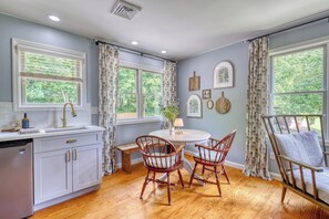 A kitchen with a dining area, wooden flooring, and large windows with curtains. - Gettysburg 2-Bedroom Suite for 4 - Kitchenette, Hot Tub & Sauna (Gettysburg)