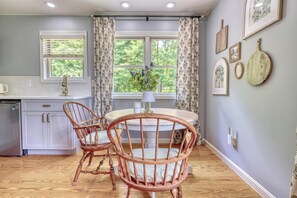 A kitchen with a dining table, chairs, and a window with curtains. - Gettysburg 2-Bedroom Suite for 4 - Kitchenette, Hot Tub & Sauna (Gettysburg)