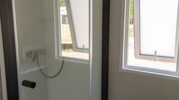 Ein Zimmer mit Dusche, Fenster und Tür.