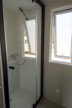 Una habitación con ducha, ventana y puerta.
