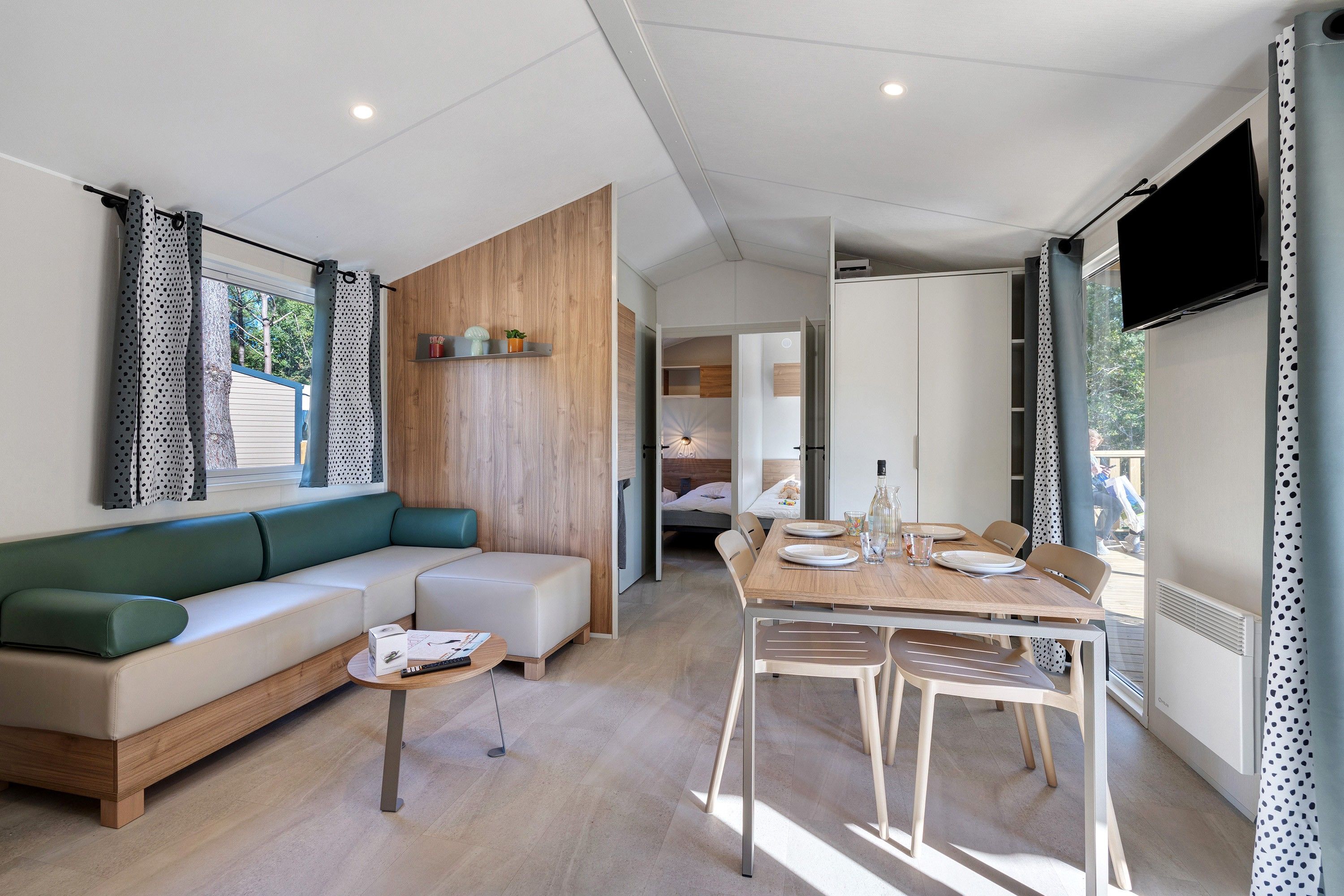 Ein stilvolles Wohnzimmer mit Sofa, Esstisch und Fernseher.