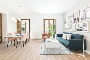 A modern living room with a dining area, a sofa, a coffee table, and a floor lamp. - Santa Ana XXXII / XLI (TUR) (Madrid)