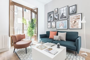 A modern living room with a sofa, coffee table, and a collection of framed pictures on the wall. - Santa Ana XXXI / XLV TUR (Madrid)