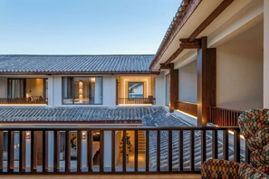A traditional building with a tiled roof and a balcony with wooden railings. - dalishaxiyunxiqiyuejingpinkezhan (Dali)