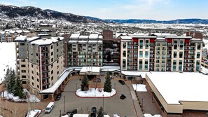 Ein Hotelkomplex mit mehreren Gebäuden, einem Innenhof und Blick auf schneebedeckte Berge.
