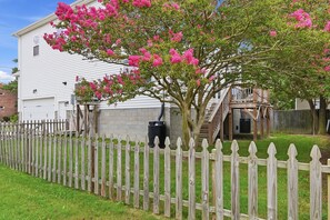 A white house with a wooden deck and a pink flowering tree. - Fabulous 4-bedroom house in tranquil Norfolk with Game Room! (Norfolk)