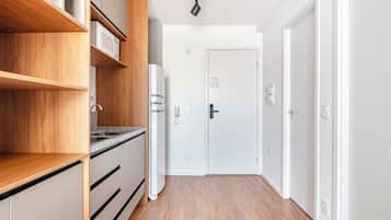A modern kitchen with wooden cabinets, a built-in oven, and a stainless steel sink.