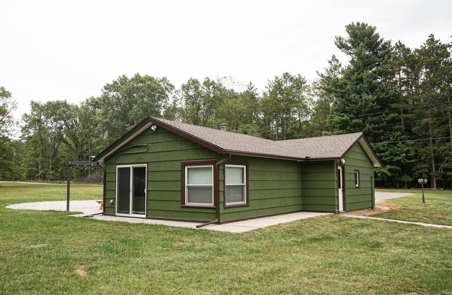 A single-story house with a front porch, a garage, and a small attached shed.