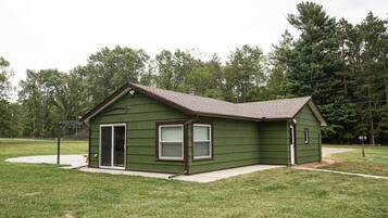 A single-story house with a front porch, a garage, and a small attached shed.