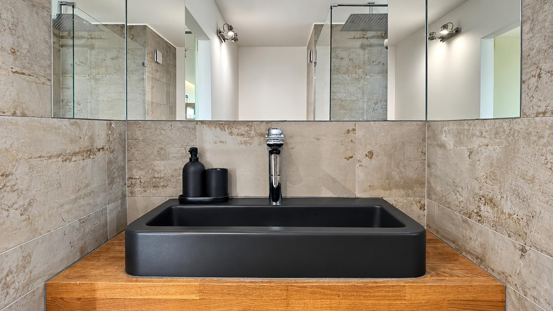 Un baño moderno con un lavamanos rectangular, un grifo y un espejo encima.