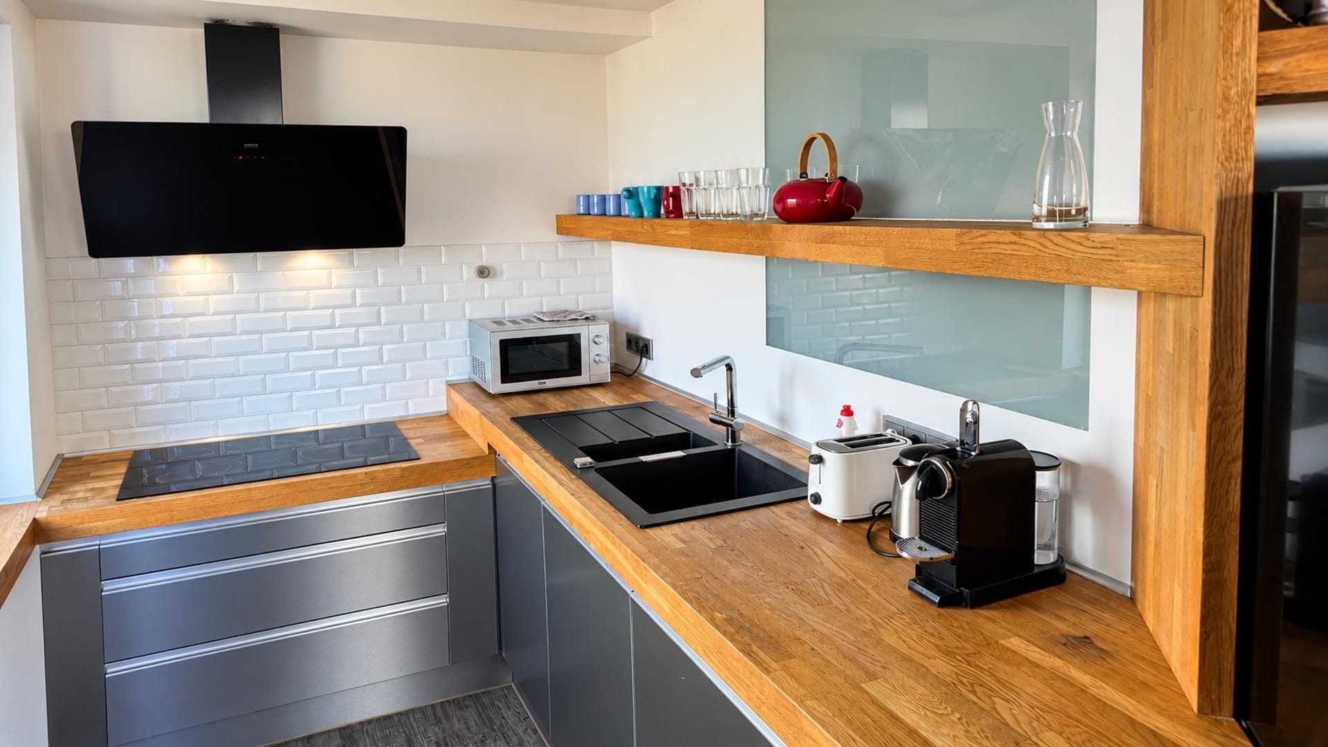 A modern kitchen with a built-in microwave, a sink, and a toaster.