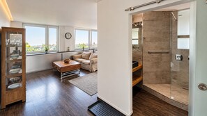 Ein modernes Wohnzimmer mit einer Couch, einem Couchtisch und einer Glasdusche.