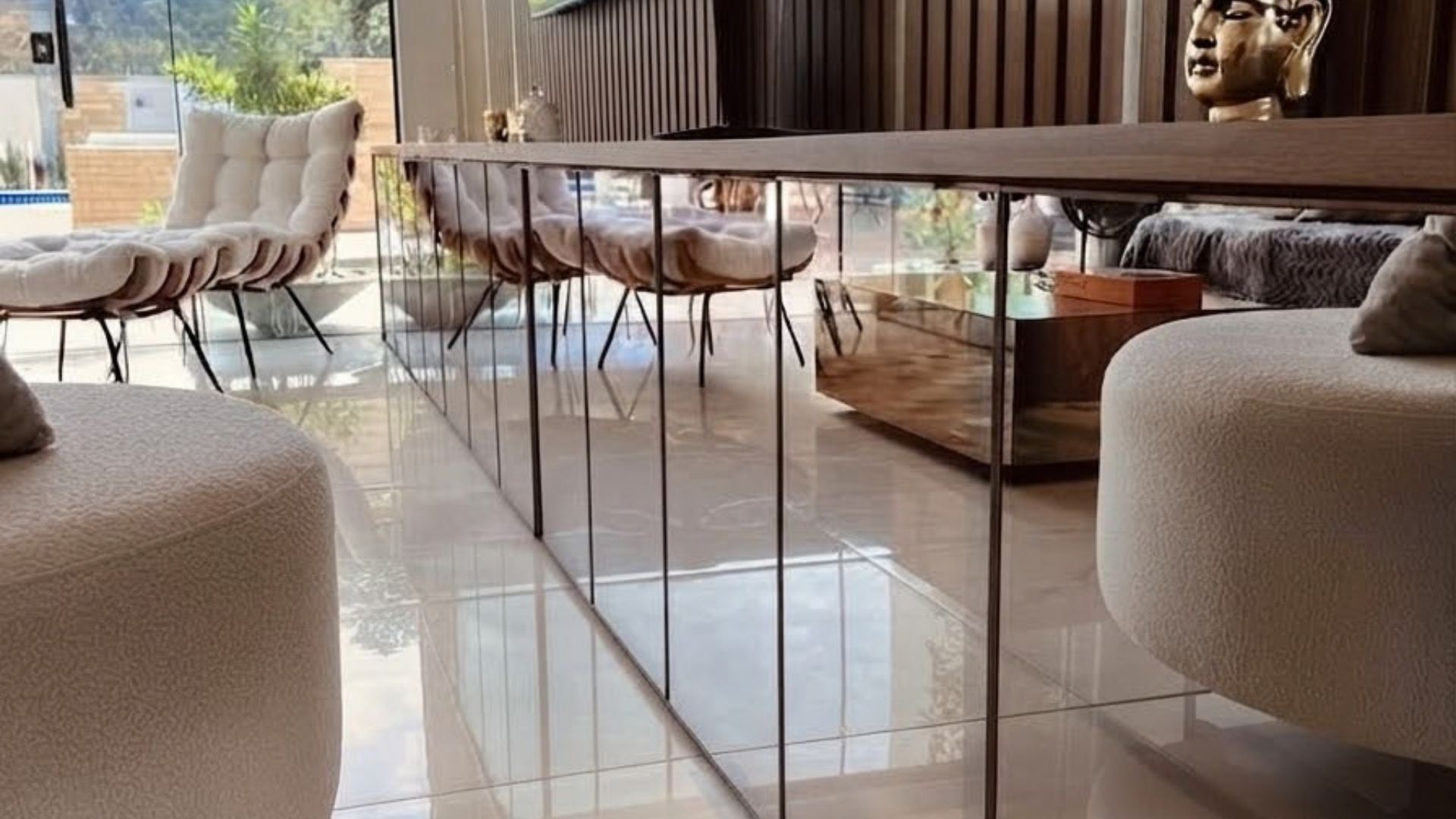 Una sala moderna con un separador de vidrio, un sofá y un comedor.
