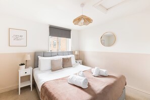 A neatly arranged bedroom with a bed, bedside tables, a window with a view, a hanging light fixture, and a framed inspirational quote on the wall. - Stylish 5-Bed Cotswolds Home|Sleeps 10|Pool table - Pass the Keys (Stroud)