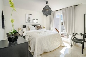 Une chambre moderne avec un lit, un bureau, une chaise et une plante en pot.