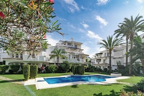 A residential building with a swimming pool, surrounded by well-maintained lawns and palm trees. - LNm530 - Great location with private roof terrace (Marbella)