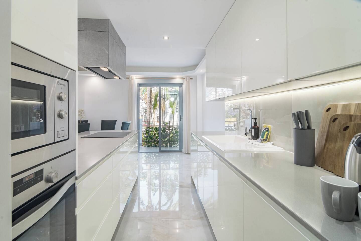 Een moderne keuken met een strak design, roestvrijstalen apparatuur en een schoon, spiegelend aanrecht.