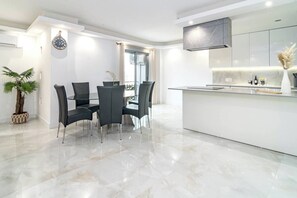 A modern kitchen with a marble countertop, a built-in oven, and a large window. - TErr69- Bright city gem in charming Old Town (Estepona)