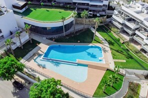 A modern hotel with a swimming pool, a circular building, and a landscaped area with palm trees. - LME9F2 - top class flat in Estepona, near beach (Estepona)
