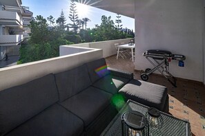 A balcony with a sofa, a small table, and a grill. - RG312 - Great 2 Bed Apt, close to Puerto Banus (Marbella)