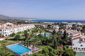 A coastal resort with multiple white buildings, a large swimming pool, and palm trees. - RG312 - Great 2 Bed Apt, close to Puerto Banus (Marbella)