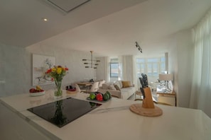 A modern kitchen with a central island, dining area, and seating space. - Sea-View 2BR, Steps to Beach & Old Town - EB4A (Estepona)