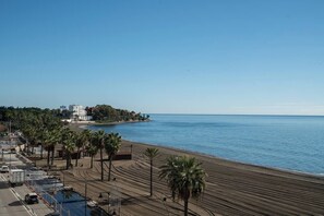 A coastal area with a beach, palm trees, and a building complex by the water. - Sea-View 2BR, Steps to Beach & Old Town - EB4A (Estepona)
