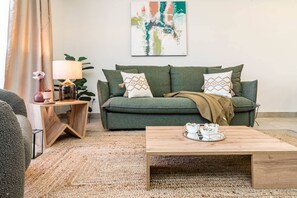 A living room with a green sofa, a coffee table, a lamp, and a painting on the wall. - INf31J - Stunning holiday home next to beach (Estepona)