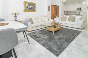 A modern living room with a white sofa, a glass coffee table, and a grey rug. - RG325 - Great 2 Bed Apt, close to Puerto Banus (Marbella)