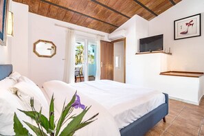 A bedroom with a bed, a TV, a wooden ceiling, and a door leading to a balcony. - Andalucian Townhouse, Pool, Near Estepona (Estepona)