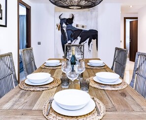 A dining table set for six with plates, glasses, and a bottle of champagne. - AE - Wonderful apartment in San Pedro centro (San Pedro de Alcantara)