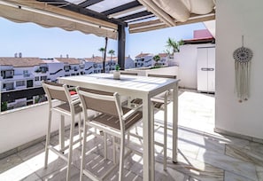 A balcony with a table and chairs, overlooking a residential area with houses and palm trees. - TEnis - Bright Bel-Air flat 2 beds, 3 terraces (Bel-Air)