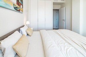 A hotel room with a bed, a nightstand, a lamp, and a wardrobe. - JG- Top modern apartment in Nueva Andalucia (Marbella)