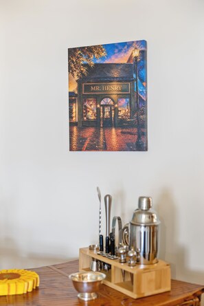 A painting of a street scene with a shop named 'MR. HENRY' and a coffee-making setup on a wooden table. - Lively Oak 175 Steps to The Village  Near NCSU (Raleigh)
