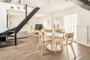 Un interior moderno con una escalera, comedor y sala de estar.