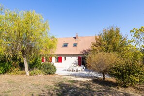 A house with a tiled roof, two windows, and a red door. - Le Repaire Paisible - Charmante maison pour 12 (Charny-Orée-de-Puisaye)