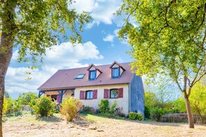 A two-story house with a sloped roof, dormer windows, and a stone chimney. - Le Repaire Paisible - Charmante maison pour 12 (Charny-Orée-de-Puisaye)