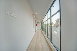 Ein Korridor mit einem Fenster auf der einen Seite und einer Steckdose auf der anderen.