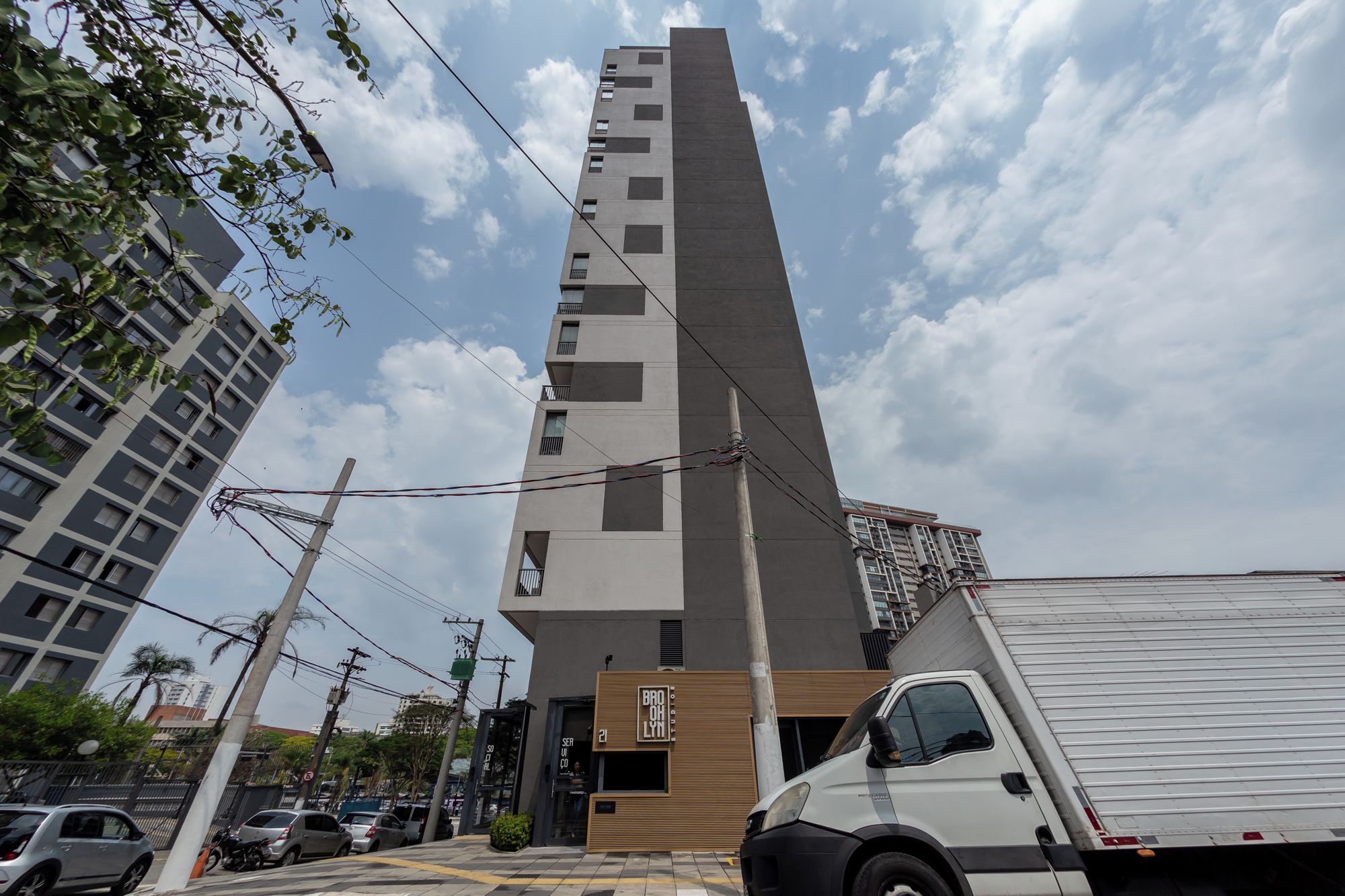 A tall, modern building with a prominent vertical structure and a ground-level entrance.