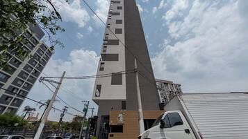 A tall, modern building with a prominent vertical structure and a ground-level entrance.